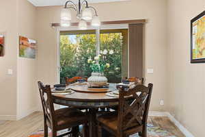 Dining area featuring light wood finished floors and a chandelier