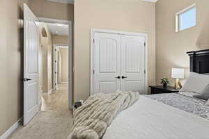 Carpeted bedroom with a closet and baseboards