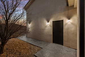 Exterior entry at dusk with stucco siding
