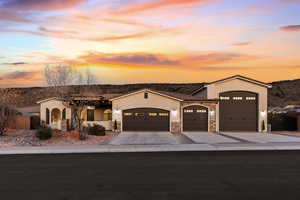 Mediterranean / spanish-style home featuring stucco siding, an attached garage, stone siding, and concrete driveway