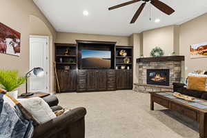Living room featuring light colored carpet, a fireplace, recessed lighting, and a ceiling fan