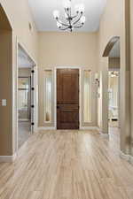 Entrance foyer with arched walkways, ceiling fan, a chandelier, and wood tiled floors