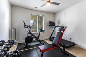 Exercise area featuring baseboards and a ceiling fan