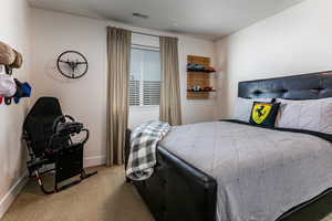 Bedroom featuring light carpet and baseboards