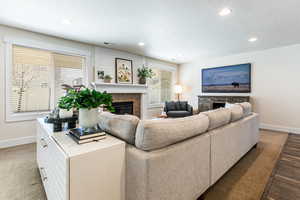 Living room featuring a glass covered fireplace, recessed lighting, and a textured ceiling