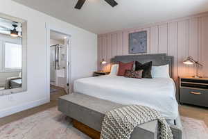 Bedroom with light colored carpet, connected bathroom, and ceiling fan