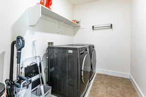 Washroom featuring separate washer and dryer and baseboards