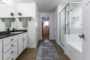 Full bath featuring a stall shower, vanity, a garden tub, and a closet