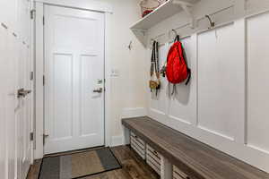 Mudroom with dark wood finished floors and baseboards