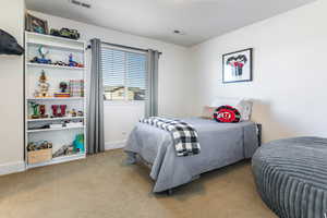 Bedroom featuring light carpet and baseboards