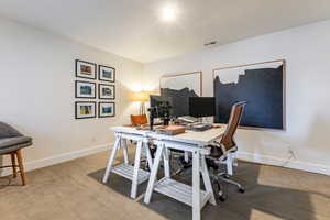 Home office with light carpet and baseboards