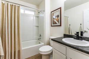 Full bath featuring shower / bathtub combination with curtain, vanity, and light tile patterned floors