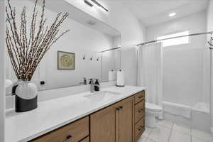 Bathroom featuring shower / bathtub combination with curtain, vanity, and recessed lighting