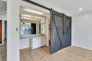 Full bathroom featuring vanity, light wood-type flooring, a ceiling fan, and recessed lighting