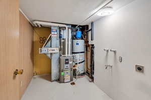 Laundry/utility room featuring water heater and heating unit