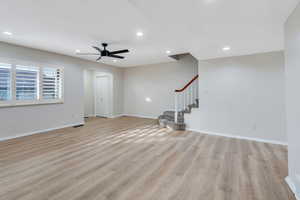 Living room featuring light wood finished floors, a ceiling fan, stairway, and recessed lighting