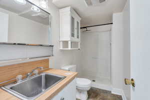 Bathroom with vanity, a shower stall, and stone finish floors