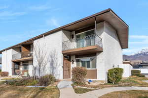 View of front facade with a balcony, brick siding, and a mountain view