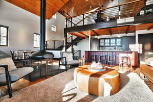 Living room with wood ceiling, hardwood / wood-style floors, high vaulted ceiling, and healthy amount of natural light