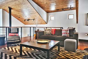 Living area featuring track lighting, wood ceiling, hardwood / wood-style floors, and vaulted ceiling