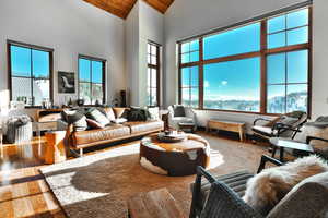 Living room featuring wood-type flooring, high vaulted ceiling, wooden ceiling, and a mountain view