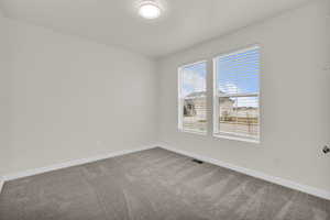 Empty room with baseboards and light colored carpet