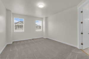 Spare room with light carpet and baseboards