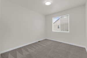 Empty room with baseboards and light colored carpet