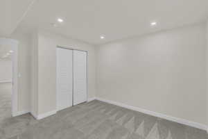 Unfurnished bedroom with recessed lighting, light colored carpet, and a closet