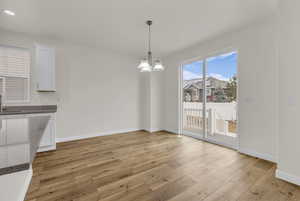 Unfurnished dining area featuring light wood-style floors and a chandelier