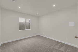 Empty room with recessed lighting and light carpet