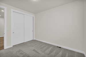 Unfurnished bedroom featuring carpet flooring and a closet
