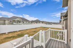 Wooden terrace with a fenced backyard and a residential view