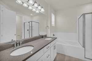 Full bathroom with a stall shower, a garden tub, and double vanity