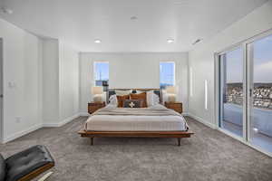 Carpeted bedroom featuring baseboards and access to outside