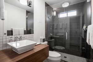 Full bathroom with vanity, a shower stall, and tile walls