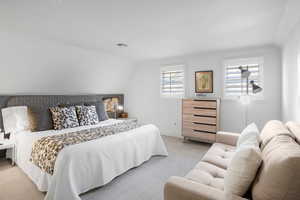 Carpeted bedroom with lofted ceiling and baseboards