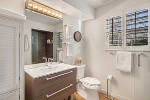 Bathroom with vanity, a tile shower, and light wood-type flooring