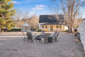 View of patio / terrace with a gazebo, an outdoor fire pit, and an outdoor structure