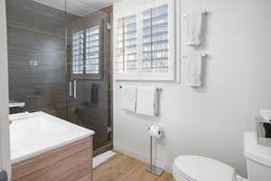Bathroom featuring vanity, a stall shower, and light wood finished floors
