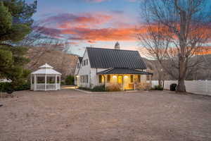 Rear view of property featuring a metal roof, a gazebo, and a standing seam roof