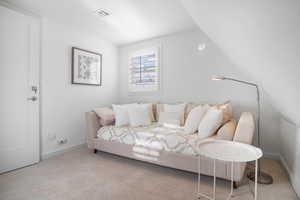 Bedroom with carpet flooring and lofted ceiling