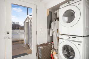 Washroom featuring stacked washer and clothes dryer and electric panel