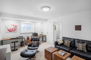 Living room with a desk, light colored carpet, and recessed lighting