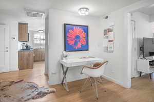 Office area featuring light wood-type flooring and a sink