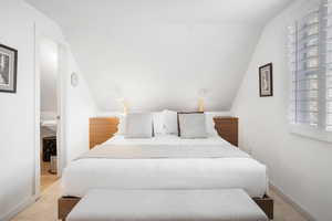 Carpeted bedroom featuring lofted ceiling