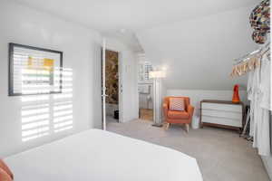 Carpeted bedroom featuring lofted ceiling