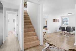 Stairway featuring wood finished floors and baseboards