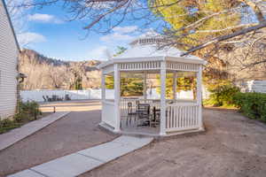 View of patio with a gazebo, a mountain view, and outdoor dining area