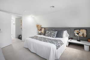 Carpeted bedroom featuring vaulted ceiling